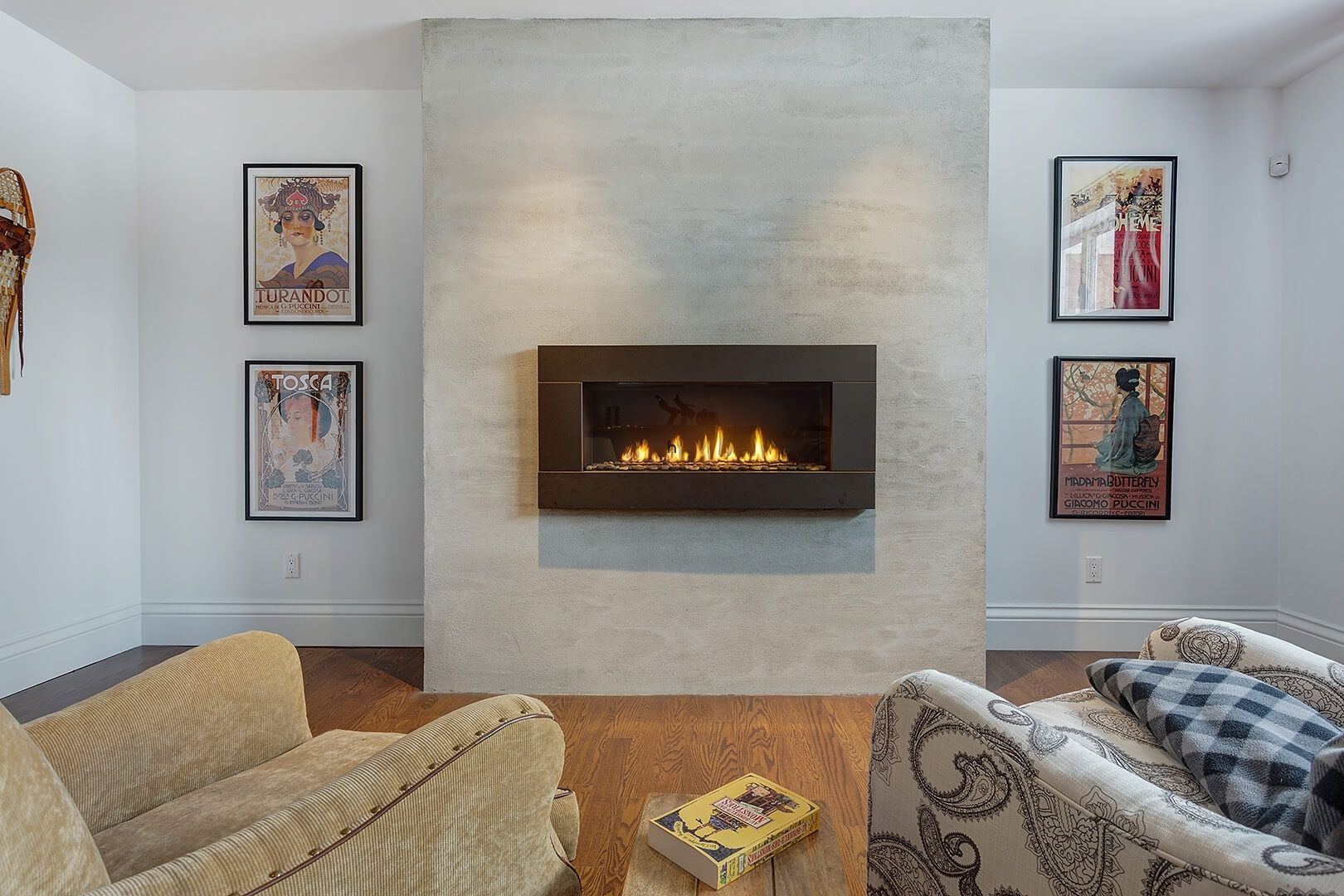 Contemporary basement fireplace with cozy seating and framed artwork.